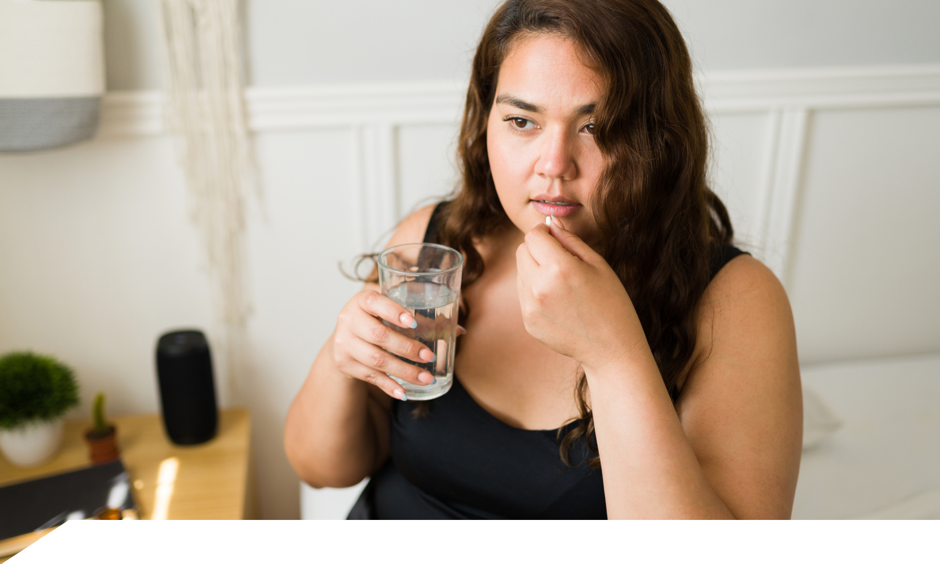 Woman holding pill and glass of water